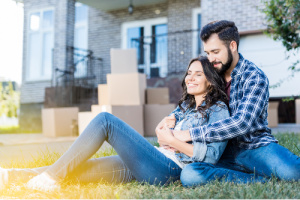 Happy couple with a new home symbolizing the power of letting go and answering, for yourself, the question of do affirmations work.