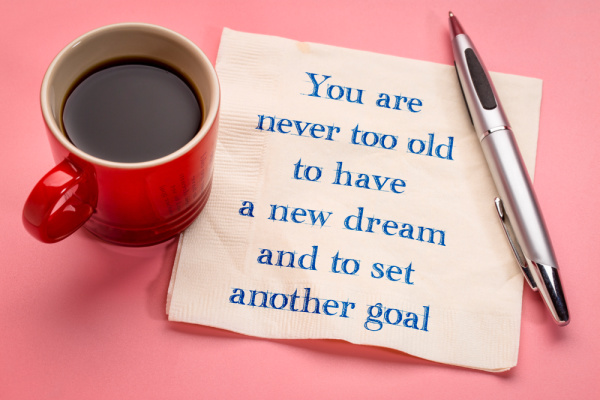 Goal setting visualization photo with paper napkin and coffee cup saying you are never too old to dream