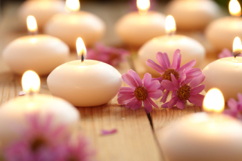 Candles and flowers creating a relaxing ambiance.  Many people feel very relaxed after a Reiki spiritual healing session.
