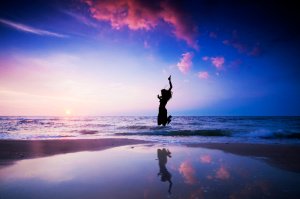 Tithe and Offering:  a feeling of joy can be encapsulated in tithing as symbolized by the happy person jumping on the beach.