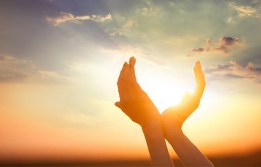 Tithe Offering:  Hands outlining the sun as if they are holding the sun.  The photo can also symbolize receiving a gift.