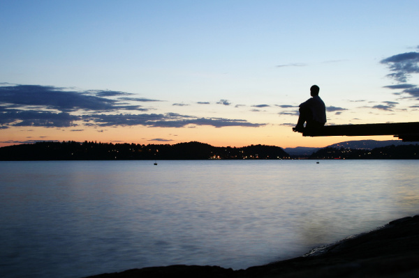 If you know the tithing definition, the question becomes why would you tithe?  The question is symbolized, here, by a photo of a man sitting at the end of a dock during sunset.